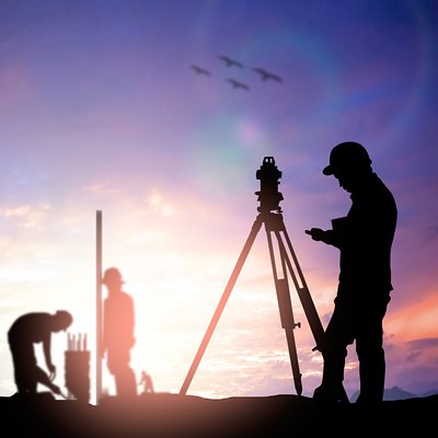 Land survey fieldwork at sunset